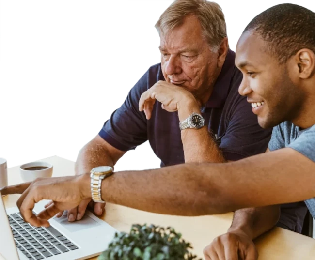 young man teaching senior man on a laptop